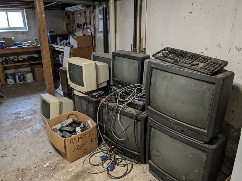 Old electronics piled in a basement corner
